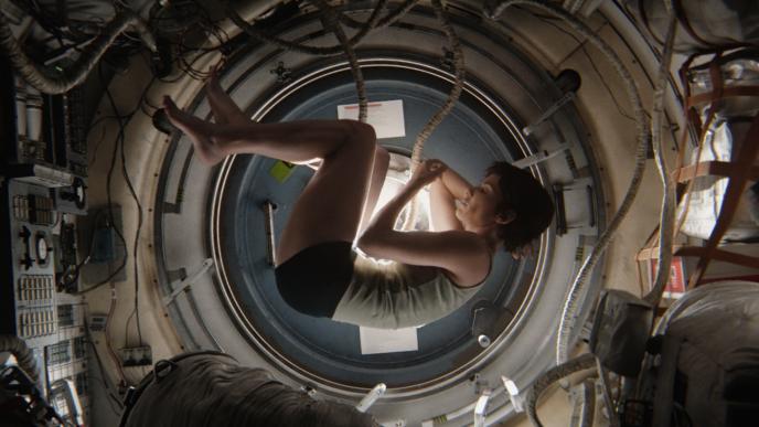 Sandra Bullock floating amongst a CGI space station background in Gravity. 