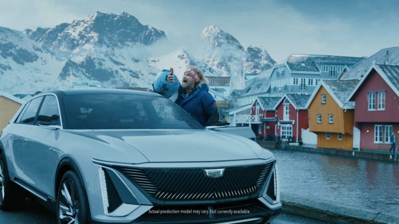 actor will ferrell standing outside of a car holding up a mobile phone while screaming. Norway in the background