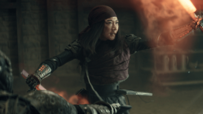 A woman with robotic arms holding red glowing swords, they are clashing with other swords coming from outside the frame. 