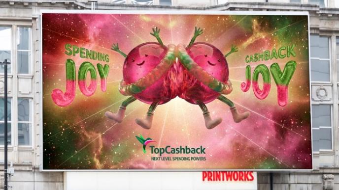 A photograph of a billboard ad showing jelly-like creatures on a cloudy background.